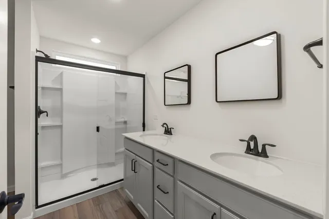a bathroom with a double vanity sink mirror and shower