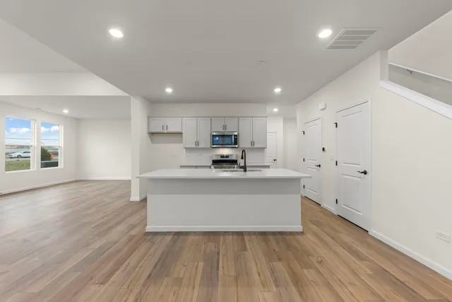 a view of kitchen with wooden floor and electronic appliances