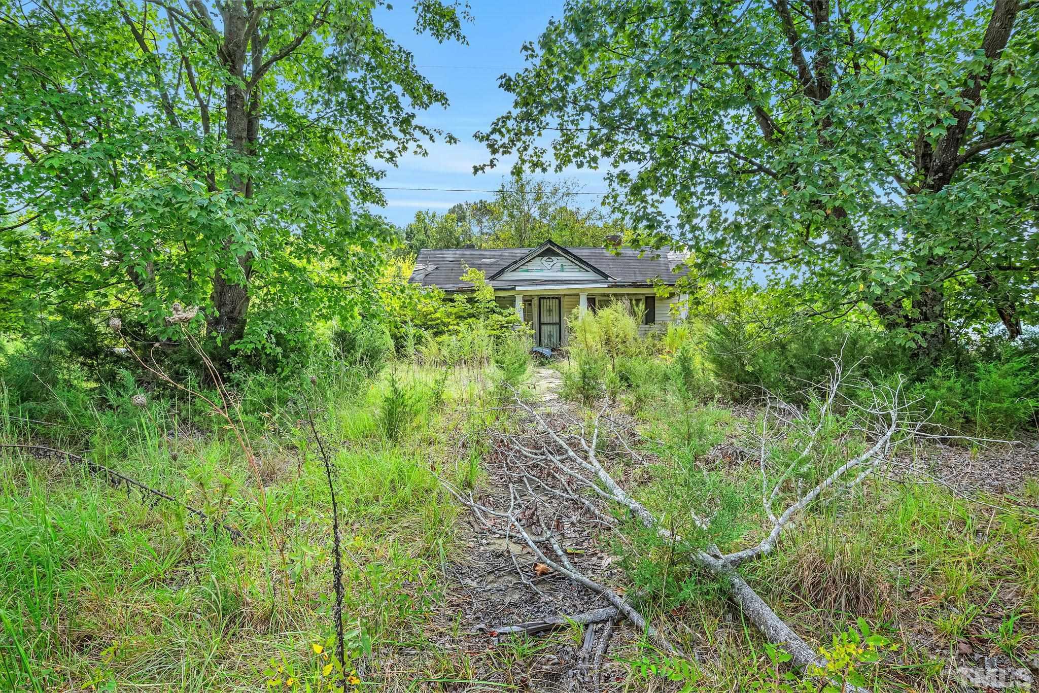 6200 Riley Hill Road Wendell, NC 27591 - Photo 2 of 12 a view of a garden with a bench under an umbrella