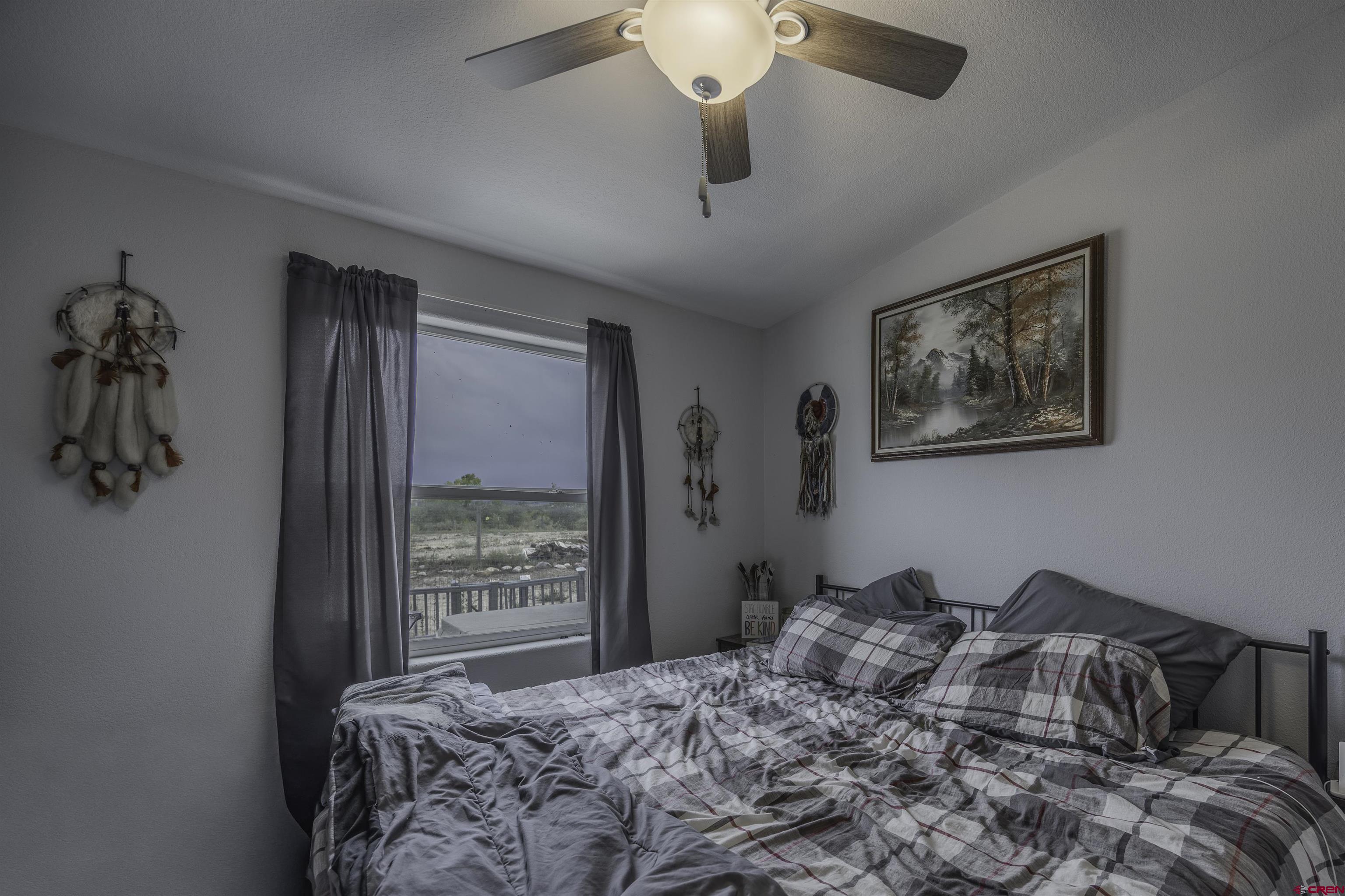 3847 5725th Road Olathe, CO 81425 - Photo 12 of 26 a bedroom with a large bed and a window