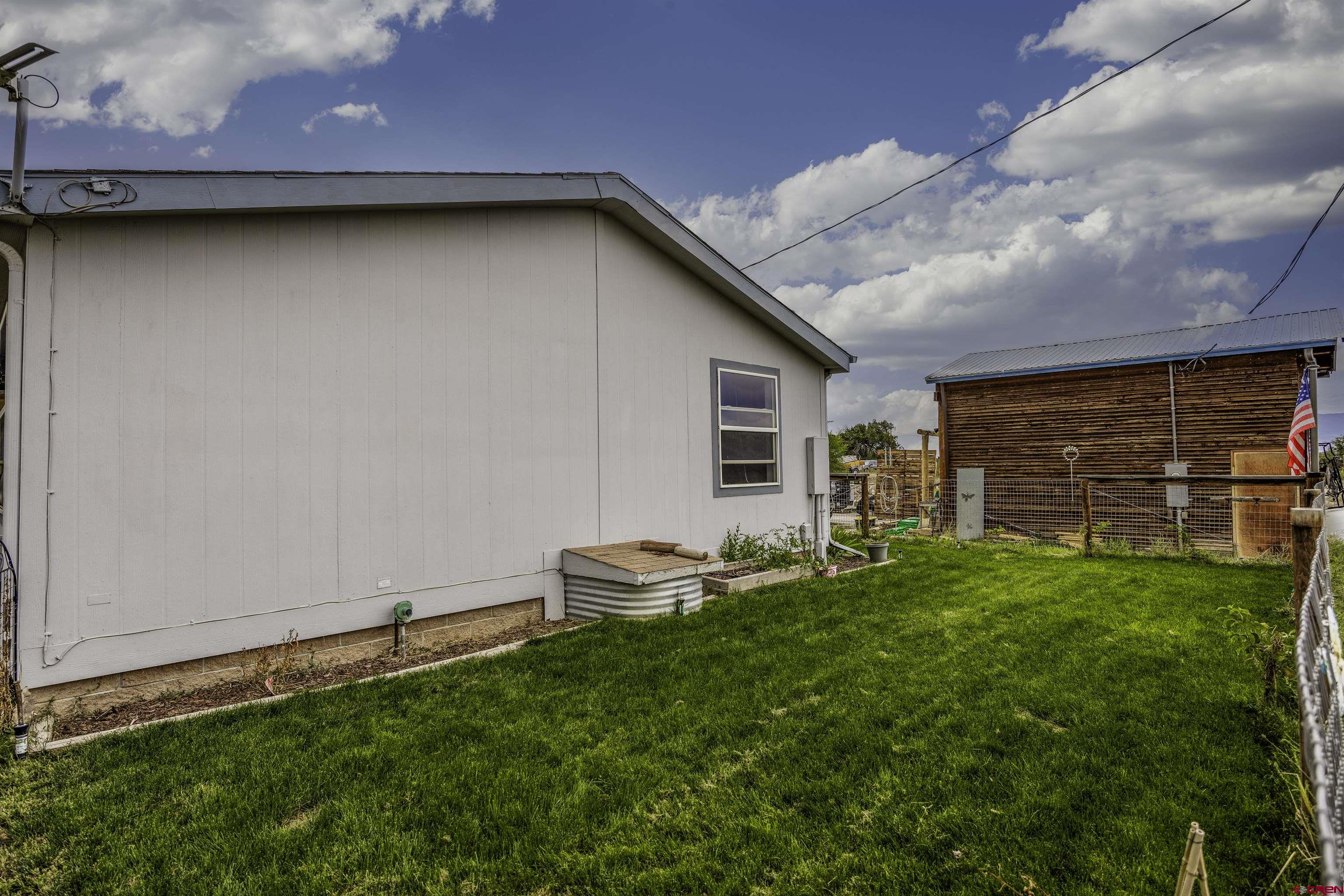 3847 5725th Road Olathe, CO 81425 - Photo 15 of 26 a backyard of a house with table and chairs