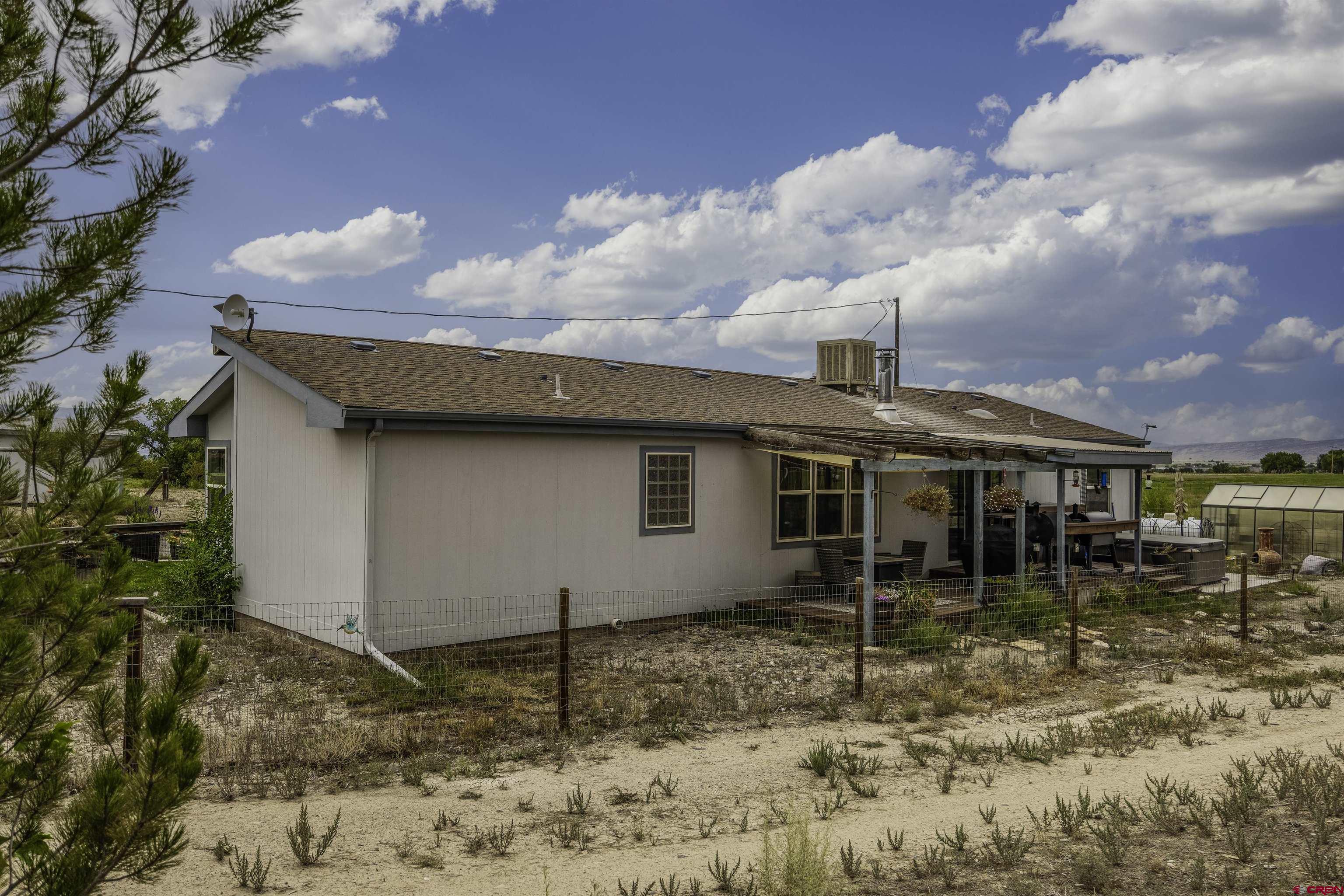 3847 5725th Road Olathe, CO 81425 - Photo 17 of 26 a backyard of a house with table and chairs