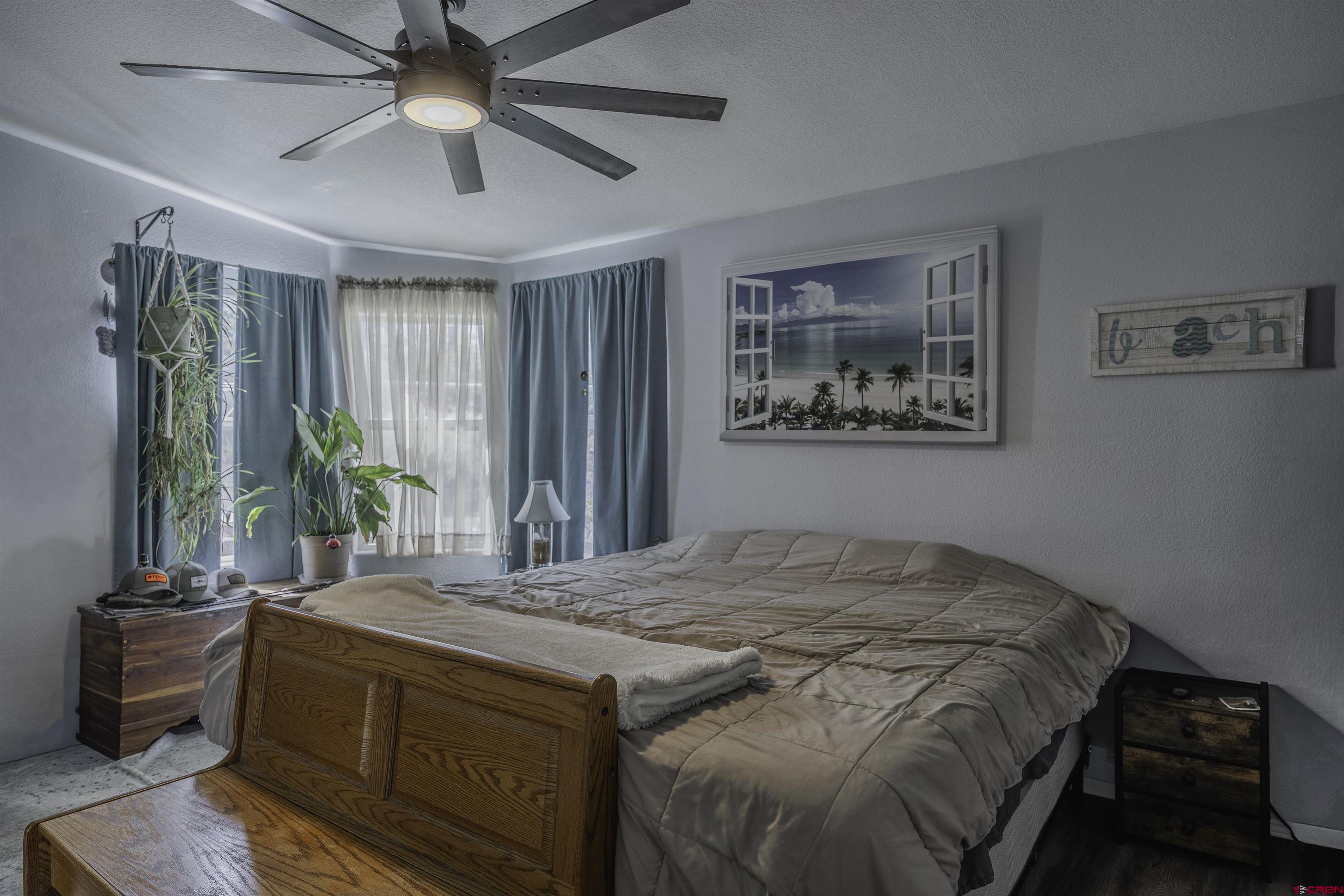 3847 5725th Road Olathe, CO 81425 - Photo 9 of 26 a bedroom with a large bed and a chandelier