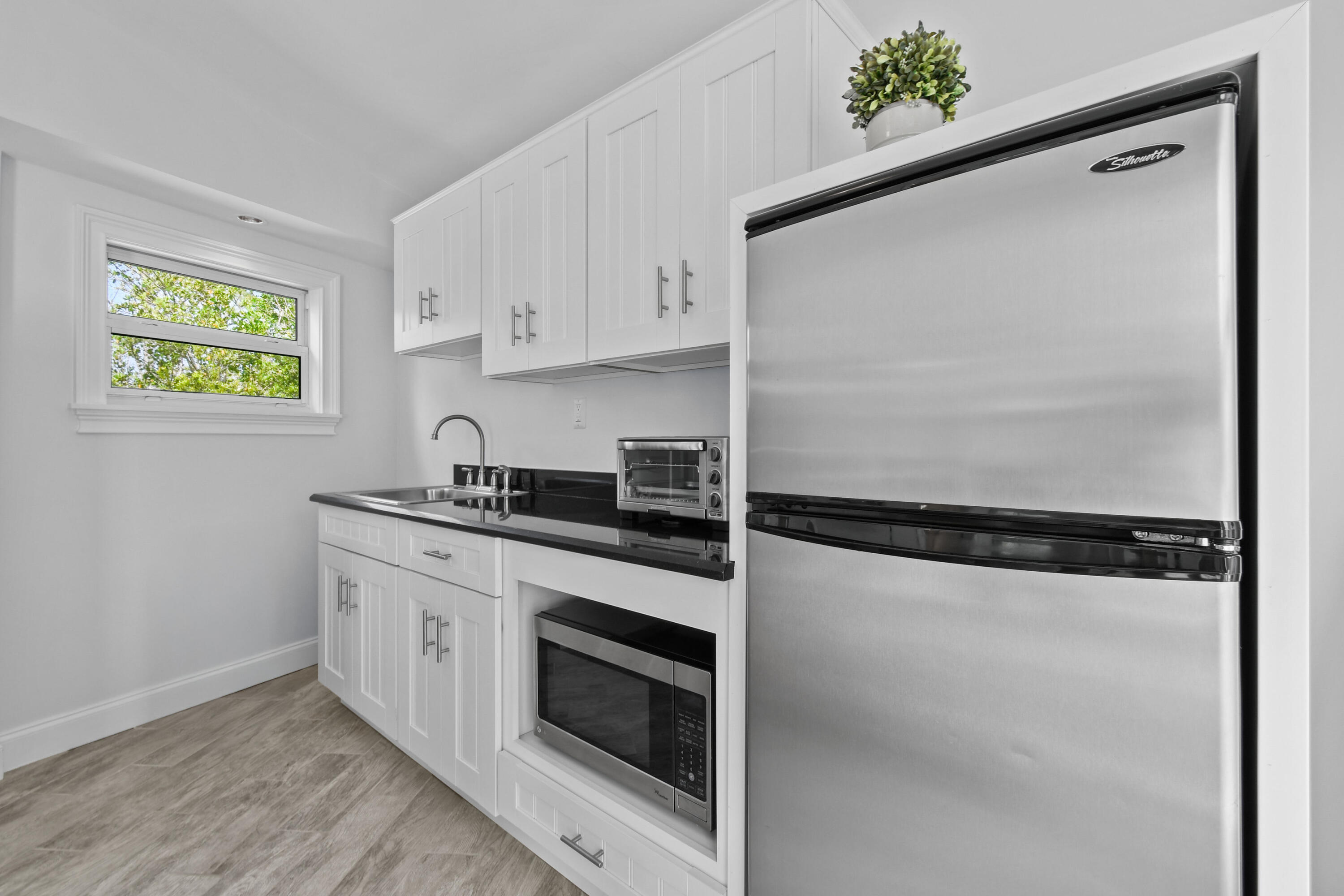 10561 Southeast Le Parc Jupiter, FL 33469 - Photo 72 of 80 a kitchen with stainless steel appliances a refrigerator sink and white cabinets