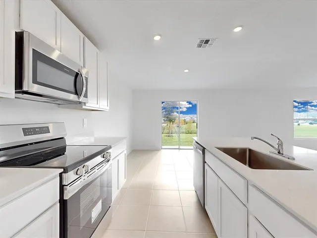a kitchen with stainless steel appliances granite countertop a sink and a microwave