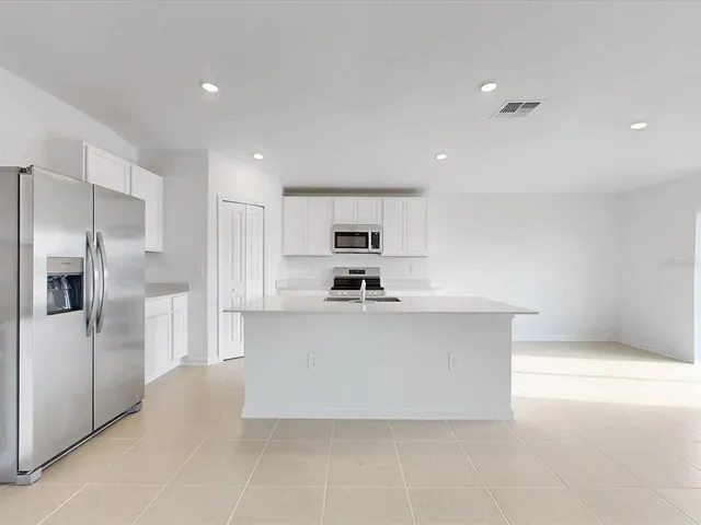 a large white kitchen with cabinets