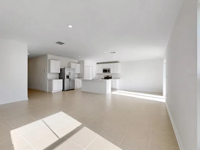 a view of kitchen with refrigerator and window