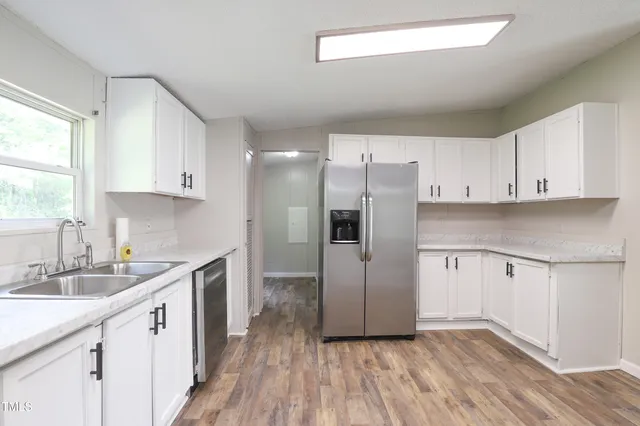 a kitchen with a sink cabinets stainless steel appliances and a window