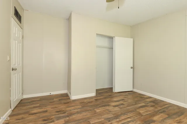 a view of an empty room with wooden floor