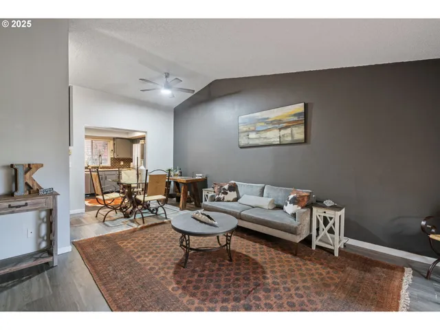 a living room with furniture and a dining table with wooden floor