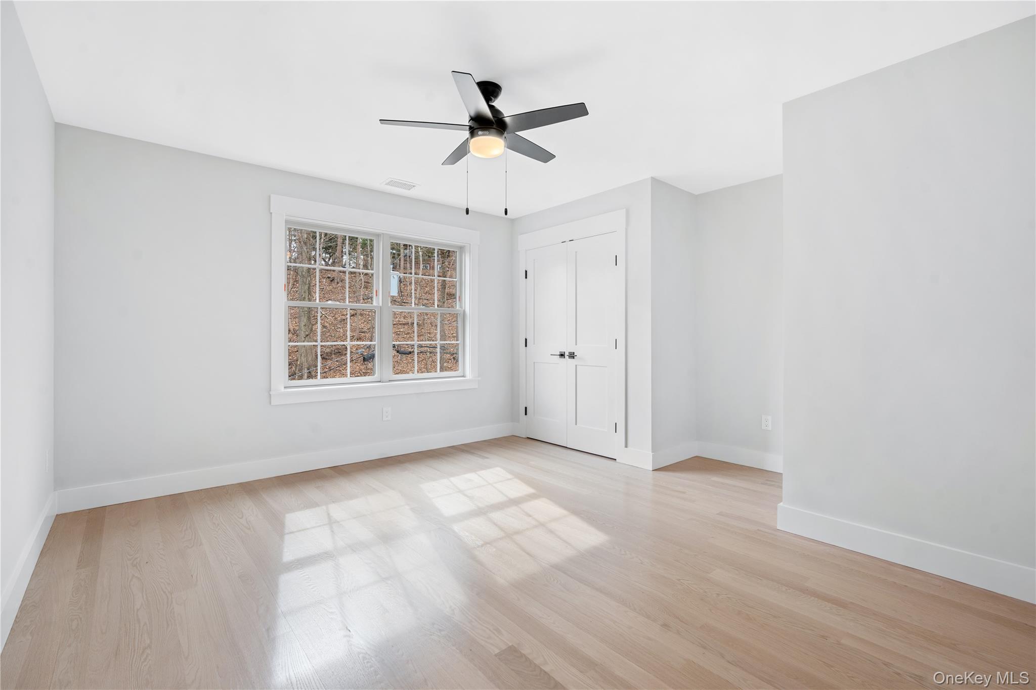 16 Stephens Lane Valhalla, NY 10595 - Photo 22 of 47 an empty room with wooden floor ceiling fan and windows