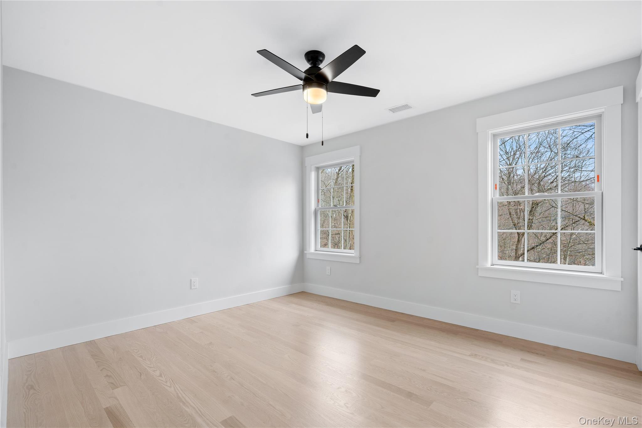 16 Stephens Lane Valhalla, NY 10595 - Photo 27 of 47 an empty room with wooden floor ceiling fan and windows