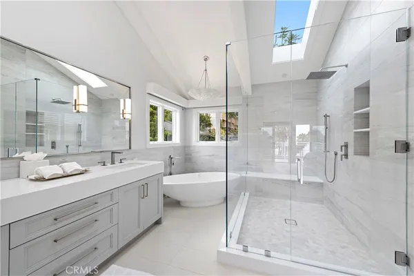 a bathroom with a tub sink shower and mirror