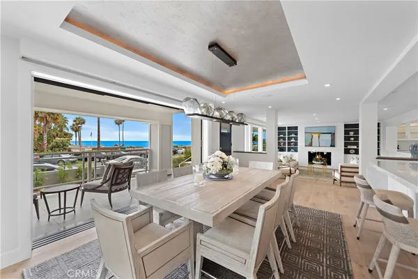 a view of a table and chairs under an umbrella with an ocean view