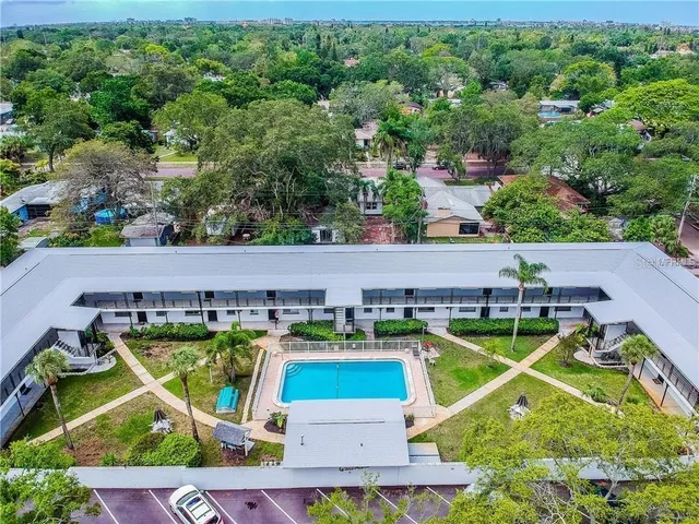 an aerial view of a house with swimming pool and outdoor seating