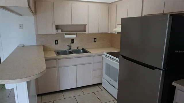 a kitchen with a sink and a refrigerator