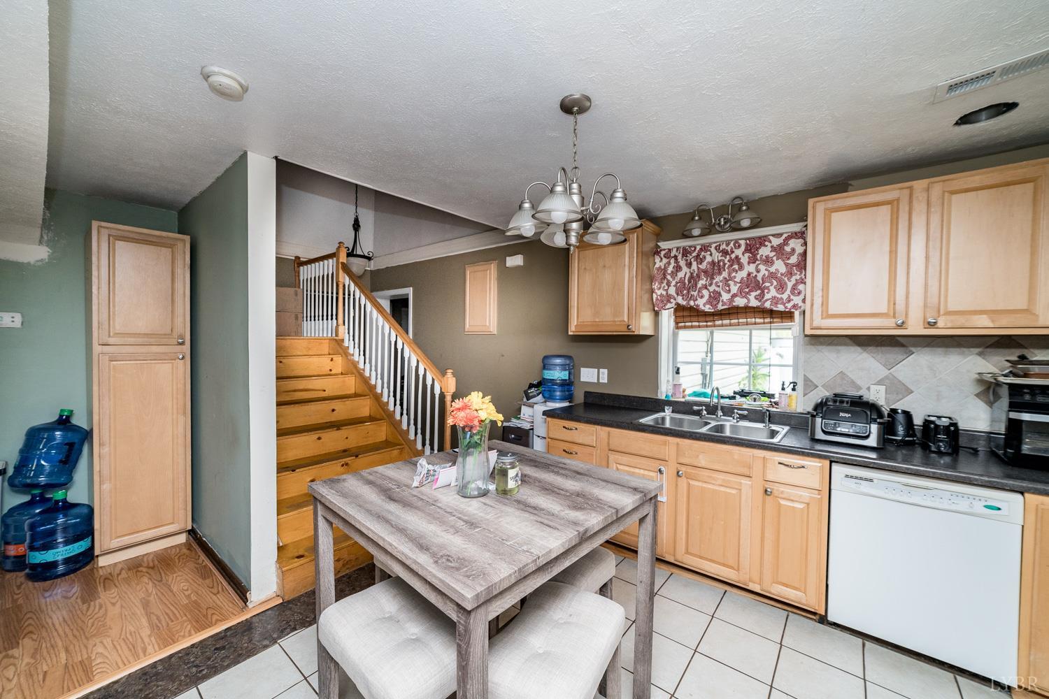 360 Theta Mill Road Gladys, VA 24554 - Photo 16 of 30 a kitchen with stainless steel appliances granite countertop a sink dishwasher a stove a microwave oven and a dining table with wooden floor