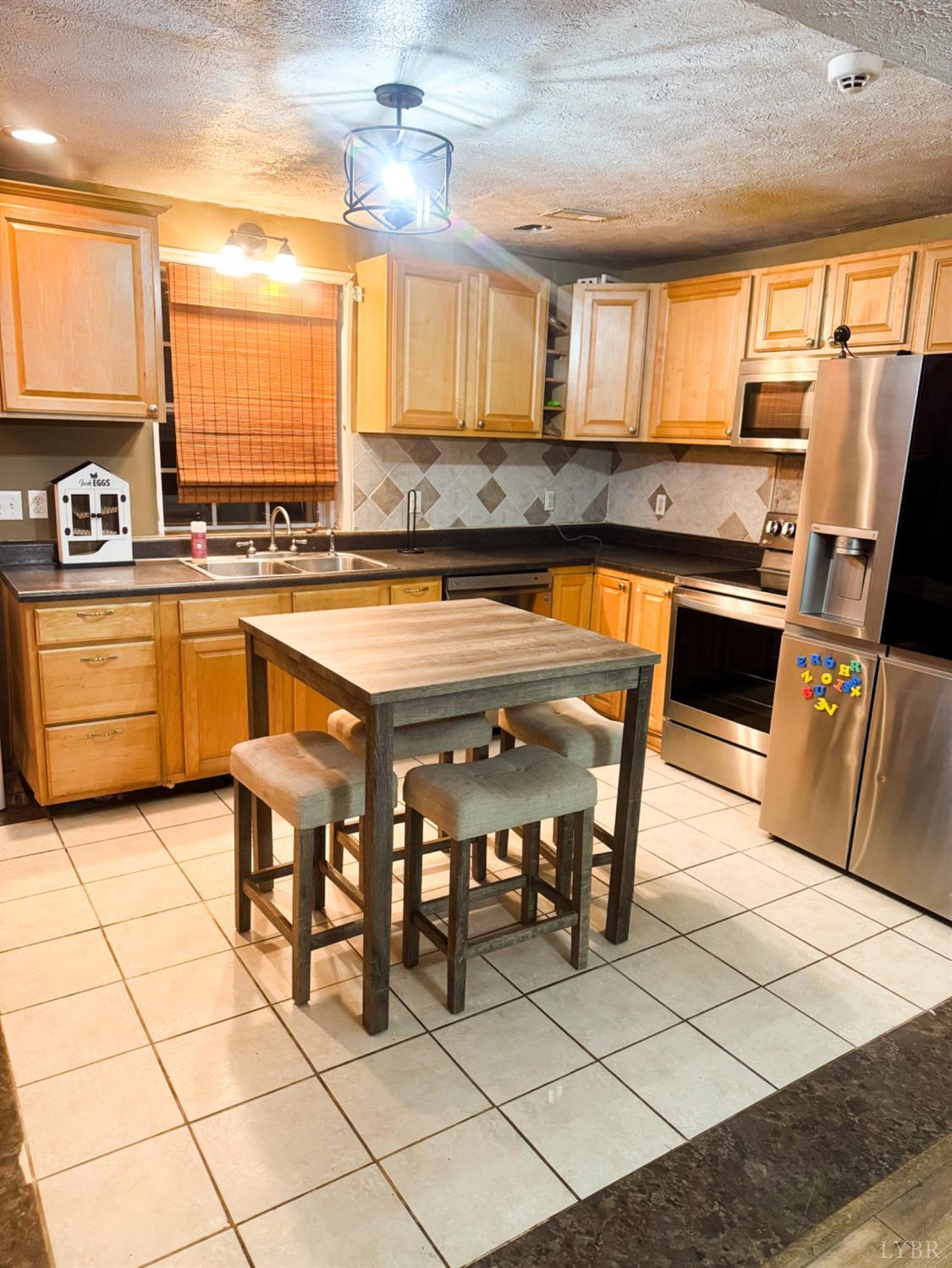 360 Theta Mill Road Gladys, VA 24554 - Photo 17 of 30 a kitchen with stainless steel appliances granite countertop a stove a sink and a microwave