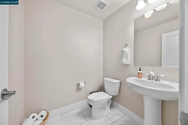 a bathroom with a toilet a sink and mirror