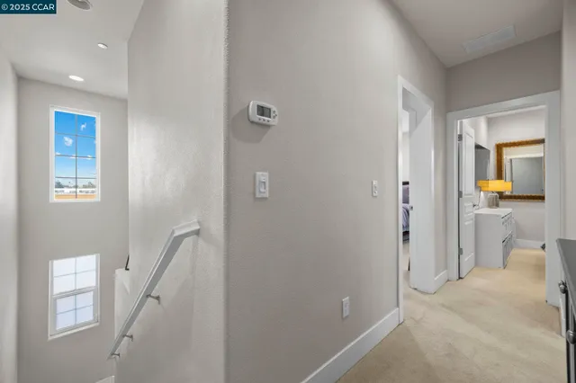 a view of a hallway with a livingroom and a livingroom with furniture