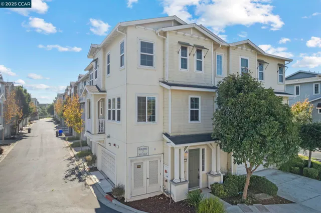 a view of a white house with large windows and a tree