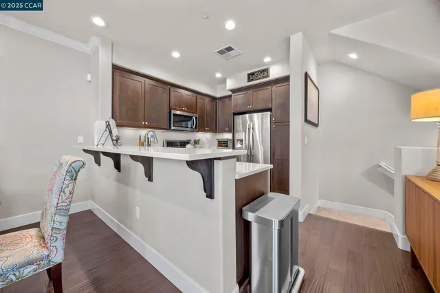 a kitchen with kitchen island stainless steel appliances cabinets a sink and a counter top space