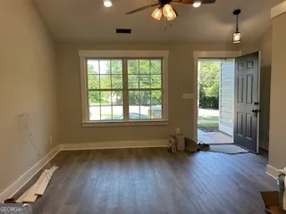 an empty room with wooden floor and windows