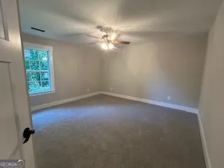 an empty room with windows and fan