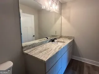 a bathroom with a granite countertop sink and a mirror