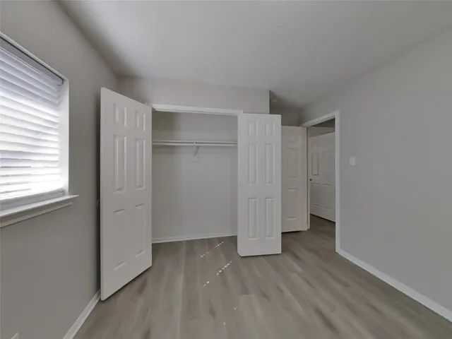 an empty room with wooden floor and window