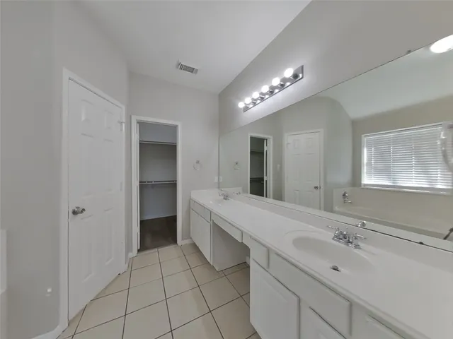 a spacious bathroom with a double vanity sink and a mirror