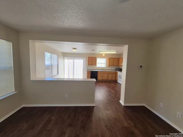 an empty room with wooden floor and a window