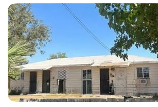 a view of a white house next to a yard