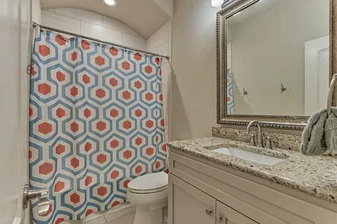 a bathroom with a sink and mirror with toilet