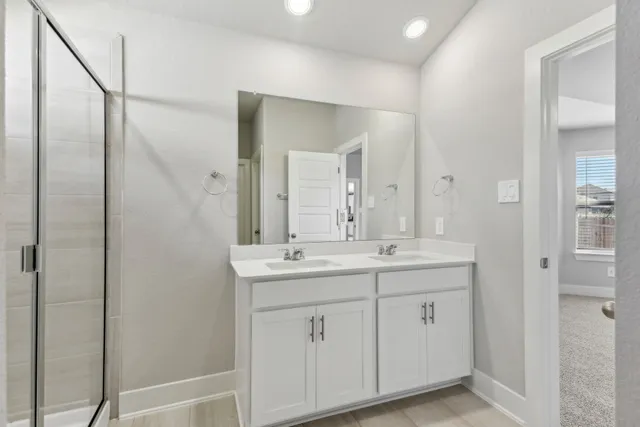 a bathroom with a double vanity sink and mirror