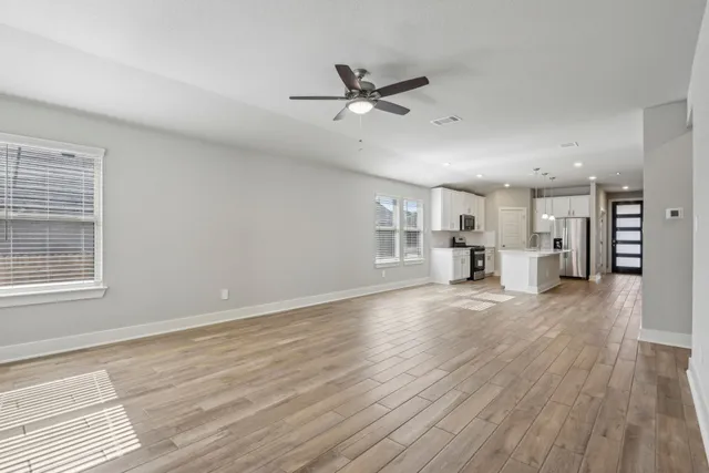 a view of a livingroom with wooden floor and a ceiling fan