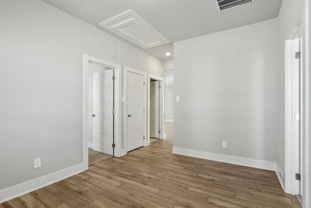 a view of an empty room with wooden floor