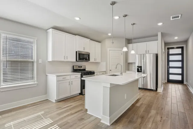 a kitchen with a sink stainless steel appliances and window