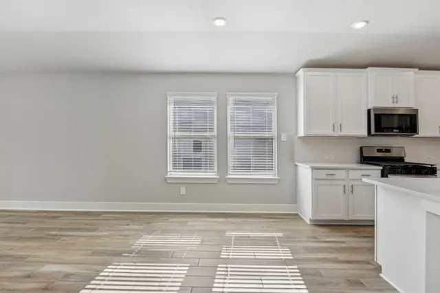 a view of a kitchen with wooden cabinet and stainless steel appliances