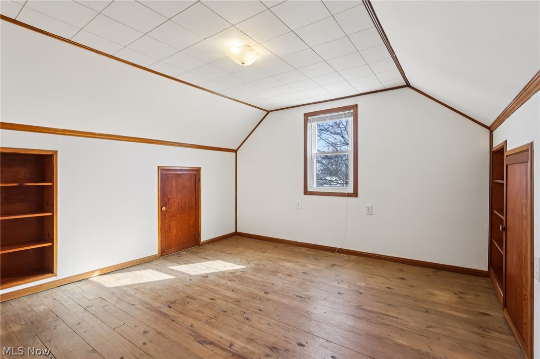 4252 Ridgeview Road Cleveland, OH 44144 - Photo 23 of 37 Bonus room featuring built in features, light wood finished floors, and vaulted ceiling