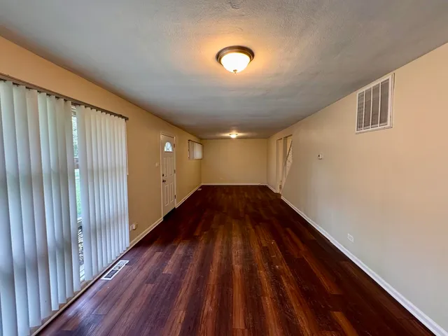 a view of an empty room with wooden floor