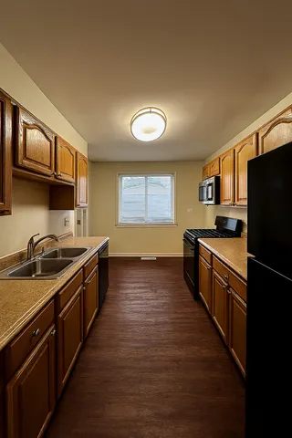 a kitchen with stainless steel appliances granite countertop a stove a sink and a refrigerator