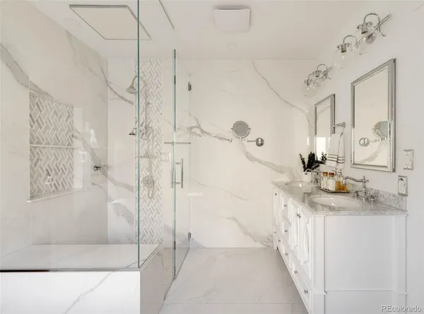 a bathroom with a granite countertop sink a mirror and shower