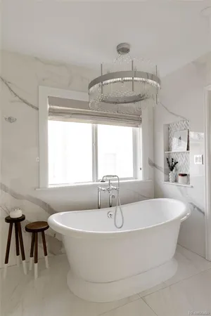 a white bath tub sitting in a bathroom next to a window