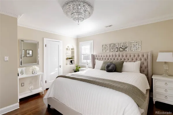 a bedroom with a large bed and a chandelier