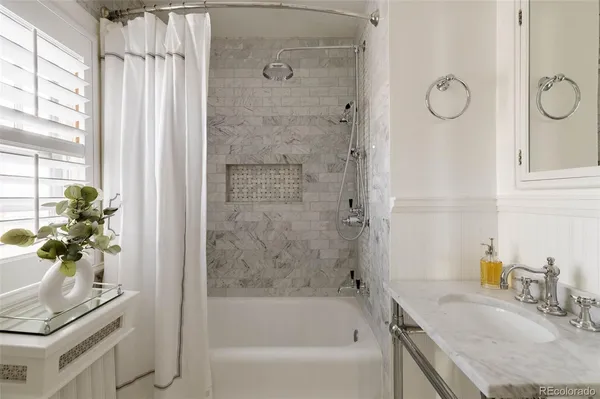 a bathroom with a granite countertop sink a mirror a vanity and a shower