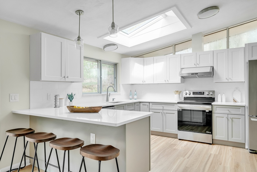 22 Partridge Road Lexington, MA 02420 - Photo 15 of 42 a kitchen with stainless steel appliances a stove a sink a stove a center island and cabinets