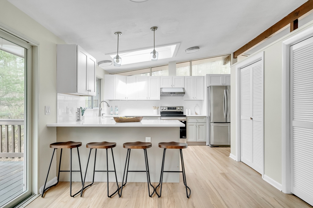 22 Partridge Road Lexington, MA 02420 - Photo 16 of 42 a kitchen with kitchen island a stove a refrigerator and wooden cabinets