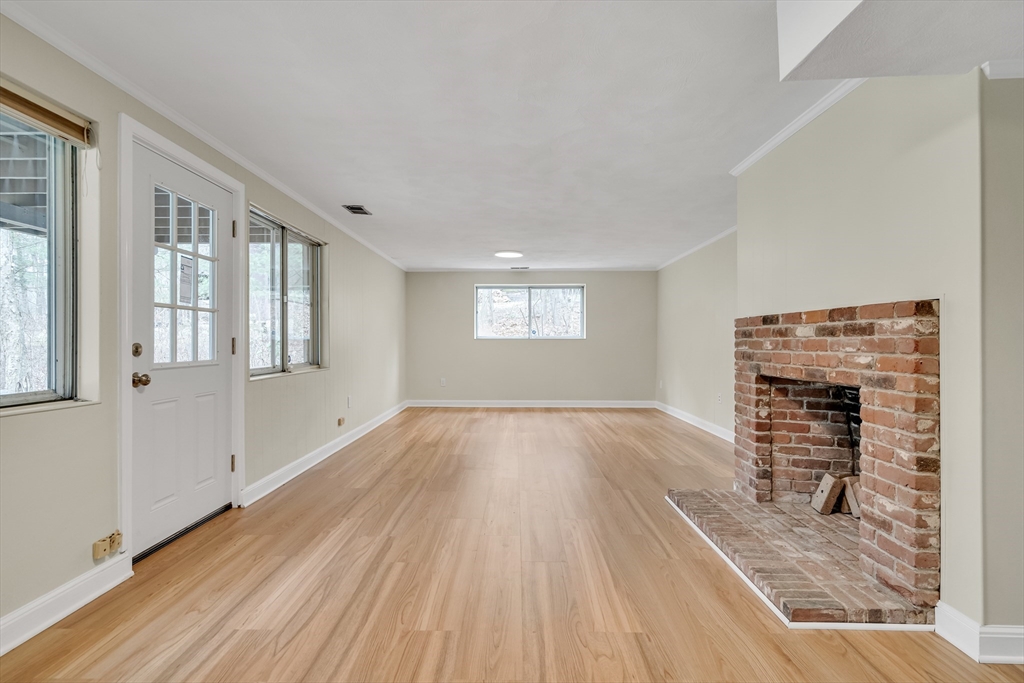 22 Partridge Road Lexington, MA 02420 - Photo 35 of 42 an empty room with windows fireplace and wooden floor