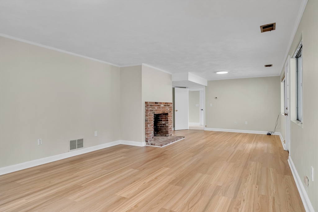 22 Partridge Road Lexington, MA 02420 - Photo 36 of 42 a view of empty room with wooden floor and fireplace
